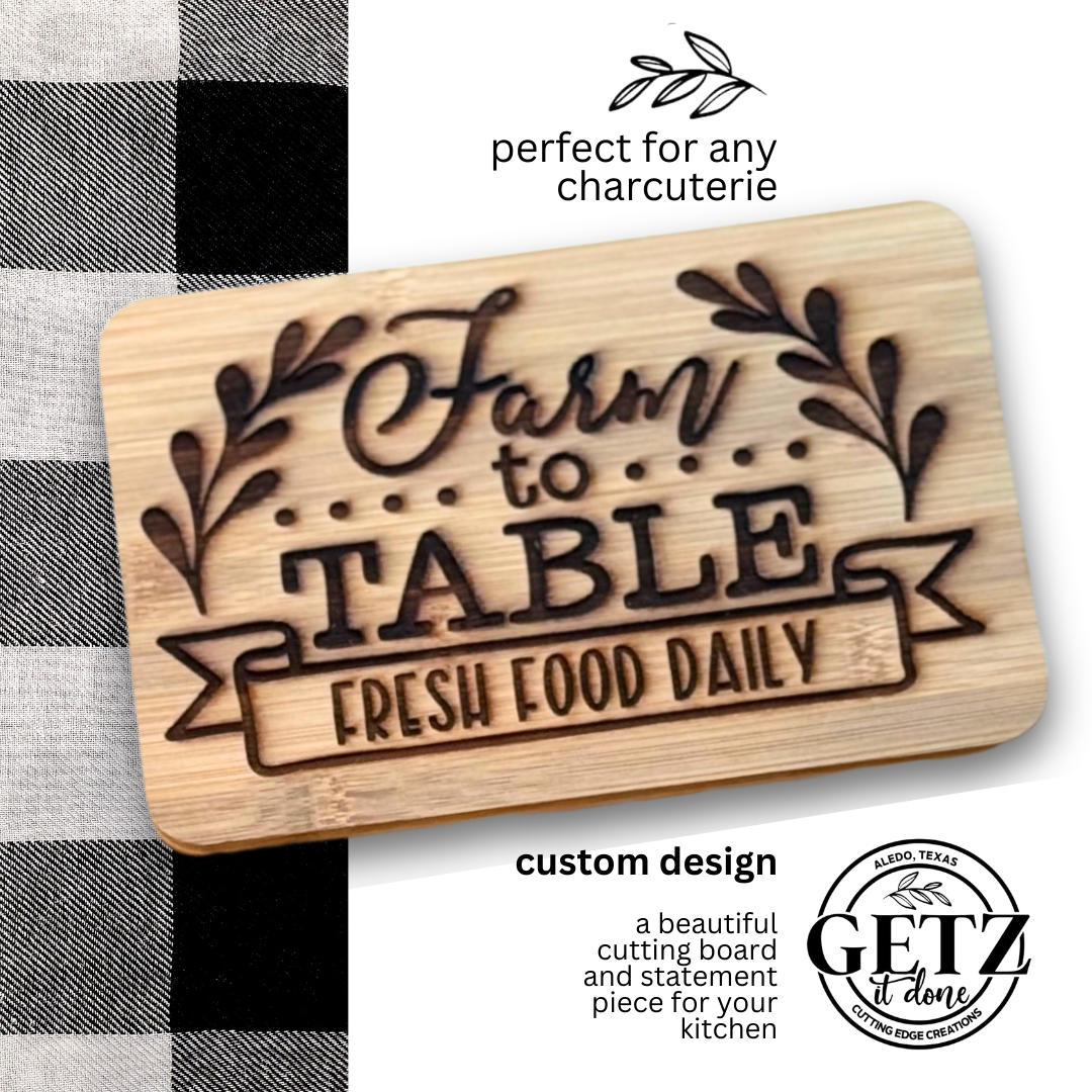 A wooden cutting board with Farm to TABLE FRESH FOOD DAILY engraved, surrounded by leafy designs. Its next to a black and white checkered fabric. Text reads perfect for any charcuterie and custom design, along with a logo stating GETZ it done with location Alto, Texas.
