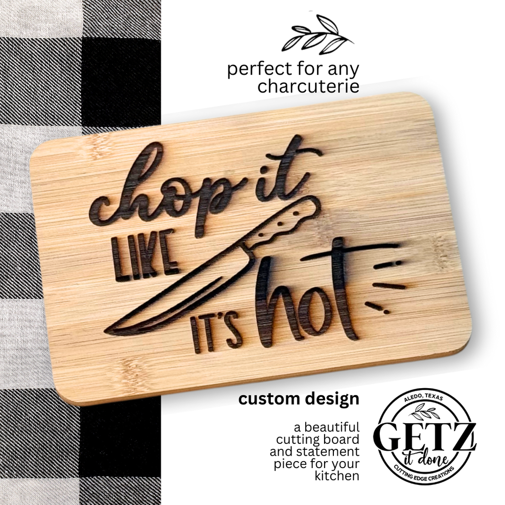 A wooden cutting board features engraved text chop it like its hot with a knife illustration. A logo reads GETZ it done, Aliso, Texas, 2020. A black and white checkered cloth partially shows on the left. Additional text reads perfect for any charcuterie and custom design.