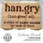 A wooden cutting board features the word hangry with pronunciation (han-gree) and defined as a state of anger caused by lack of food. Below is the Getz It Done logo with a Texas outline, advertising the custom cutting board design.