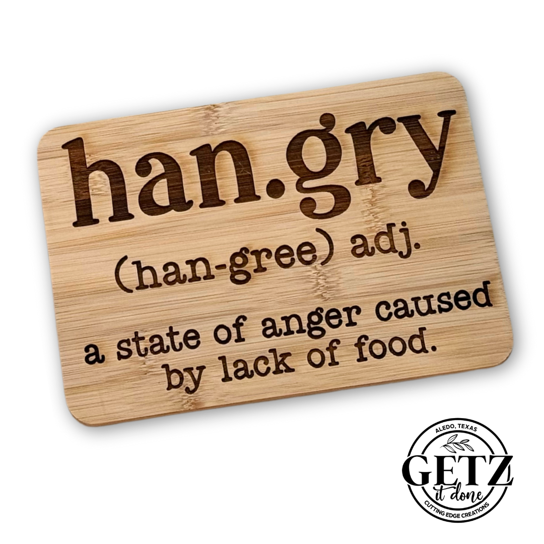 A wooden plaque with the word han.gry in bold, dark brown letters. Below, it reads (han-gree) adj. a state of anger caused by lack of food. In the bottom right corner is a circular logo with GETZ done and ALTO, TEXAS CUTTING EDGE CREATIONS inscribed.