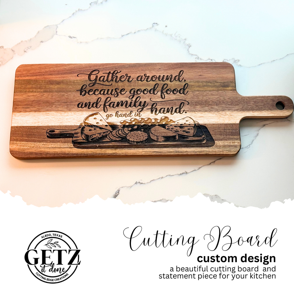A wooden cutting board features an engraved message: Gather around, because good food and family go hand in hand, alongside an illustration of various foods. The board is on a light-colored surface. A logo and text reading Cutting Board custom design are included in the image.