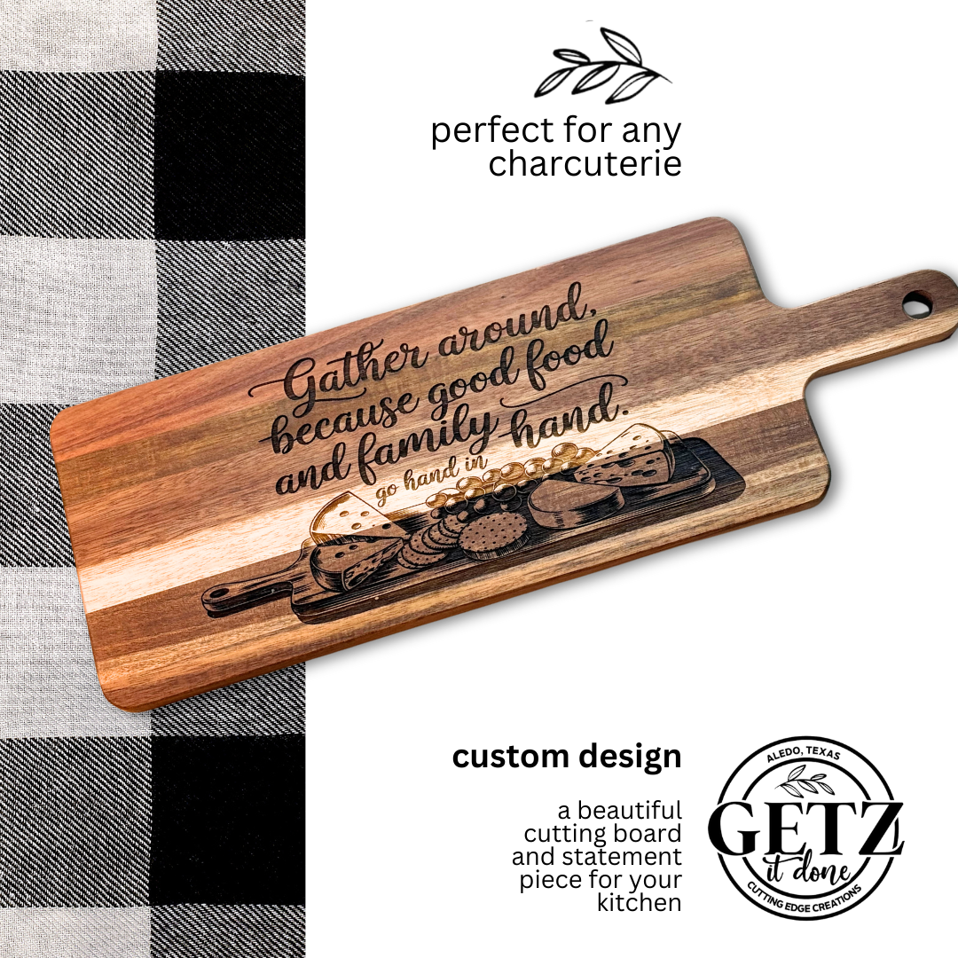 A wooden cutting board features engraved text: Gather around, because good food and family go hand in hand. It shows a charcuterie design with cheese and crackers. The background includes a black and white checkered fabric. Text reads perfect for any charcuterie and custom design.