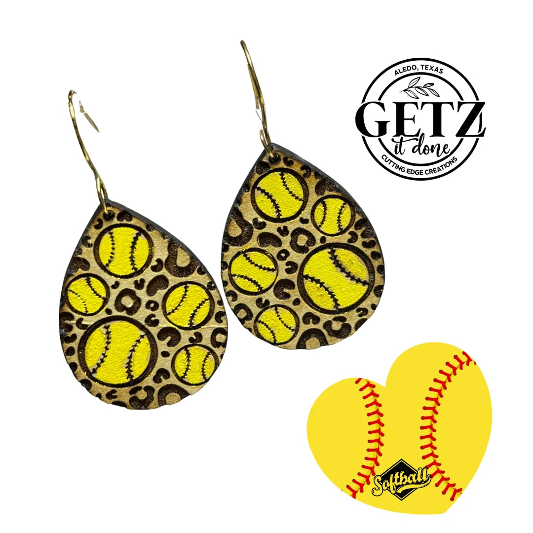 Leopard teardrop earrings with yellow softball designs, featuring stitching details. Background includes the GETZ it done logo with Aledo, Texas text, and a heart-shaped image of a yellow softball with red stitching and the word Softball in stylized script.