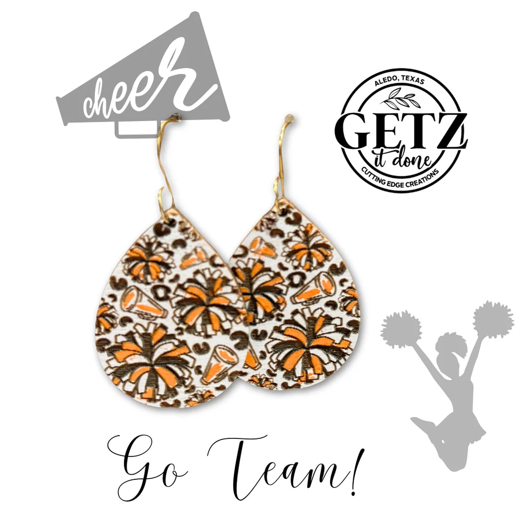 These Vibrant Teardrop Cheerleader Earrings are laser cut, hand-painted with orange, black, and white motifs featuring pompoms and megaphones. The Getz It Done logo and cheer text appear at the top, while a cheerleader silhouette and Go Team! text adorn the bottom.