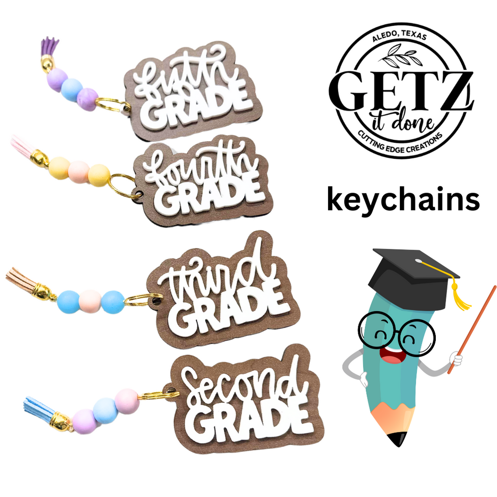Four school-themed keychains feature Sixth Grade, Fourth Grade, Third Grade, and Second Grade in white text on wood, each with colorful beads and a tassel. A smiling pencil with glasses and a graduation cap points to a GETZ it done logo in the top right corner.