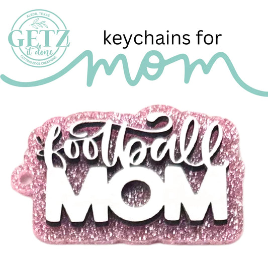 A pink glittery keychain with football MOM in white text is shown. The ad is for keychains for mom by Getz It Done, a cutting edge creations business in Aledo, Texas. The text features playful cursive fonts and includes a company logo in the top left corner.