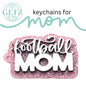 A pink glittery keychain with football MOM in white text is shown. The ad is for keychains for mom by Getz It Done, a cutting edge creations business in Aledo, Texas. The text features playful cursive fonts and includes a company logo in the top left corner.