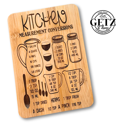 Wooden kitchen conversion chart with illustrations of measuring cups and spoons. Includes gallon, quart, pint, and cup conversions in milliliters, and tablespoons to teaspoons. Contains the text GETZ it done with a circular logo in the top right corner.