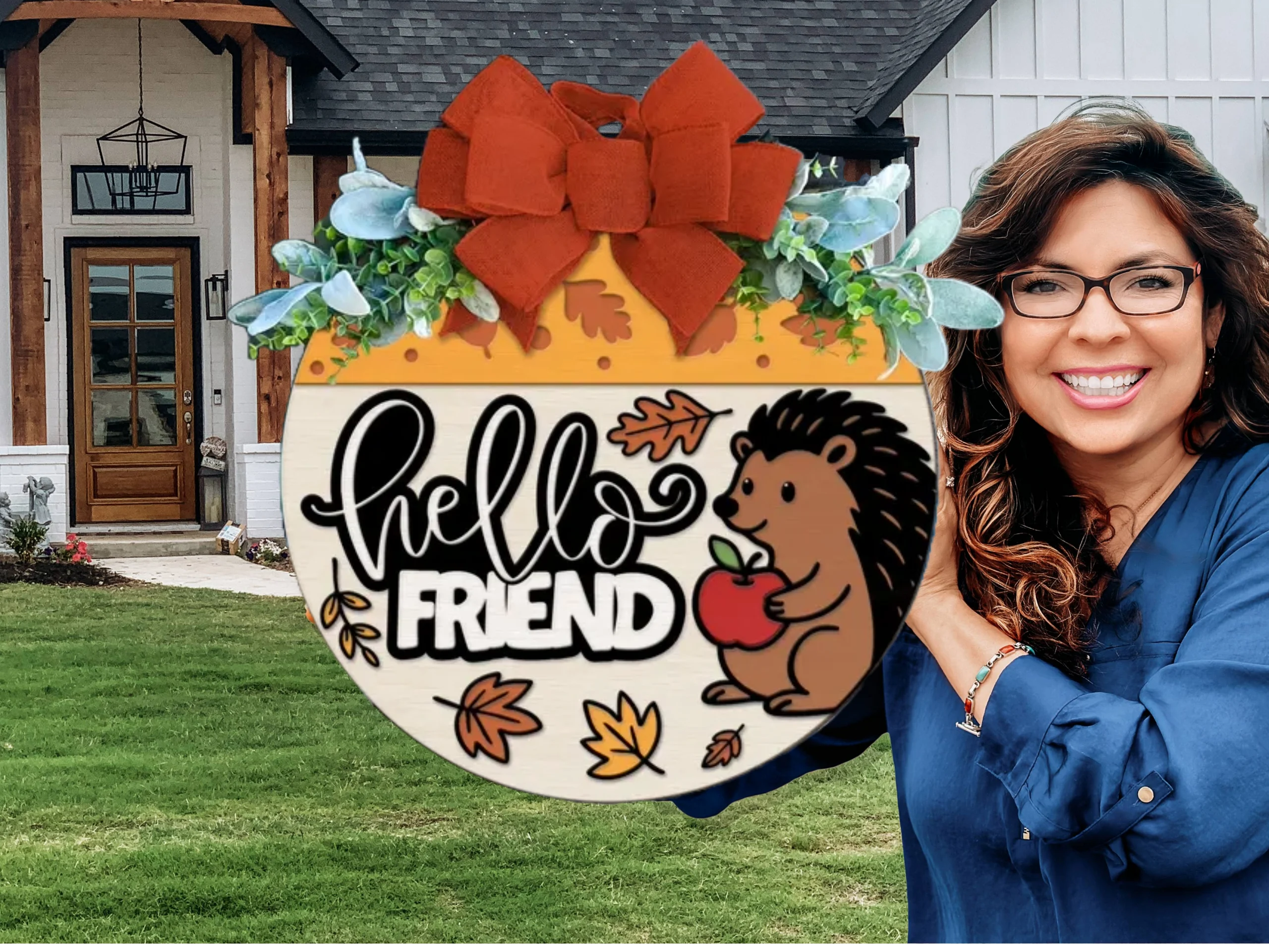 A smiling woman holds a round autumn-themed sign that says hello FRIEND with a cartoon hedgehog, leaves, and an apple. She stands in front of a modern house with white siding and wood accents.