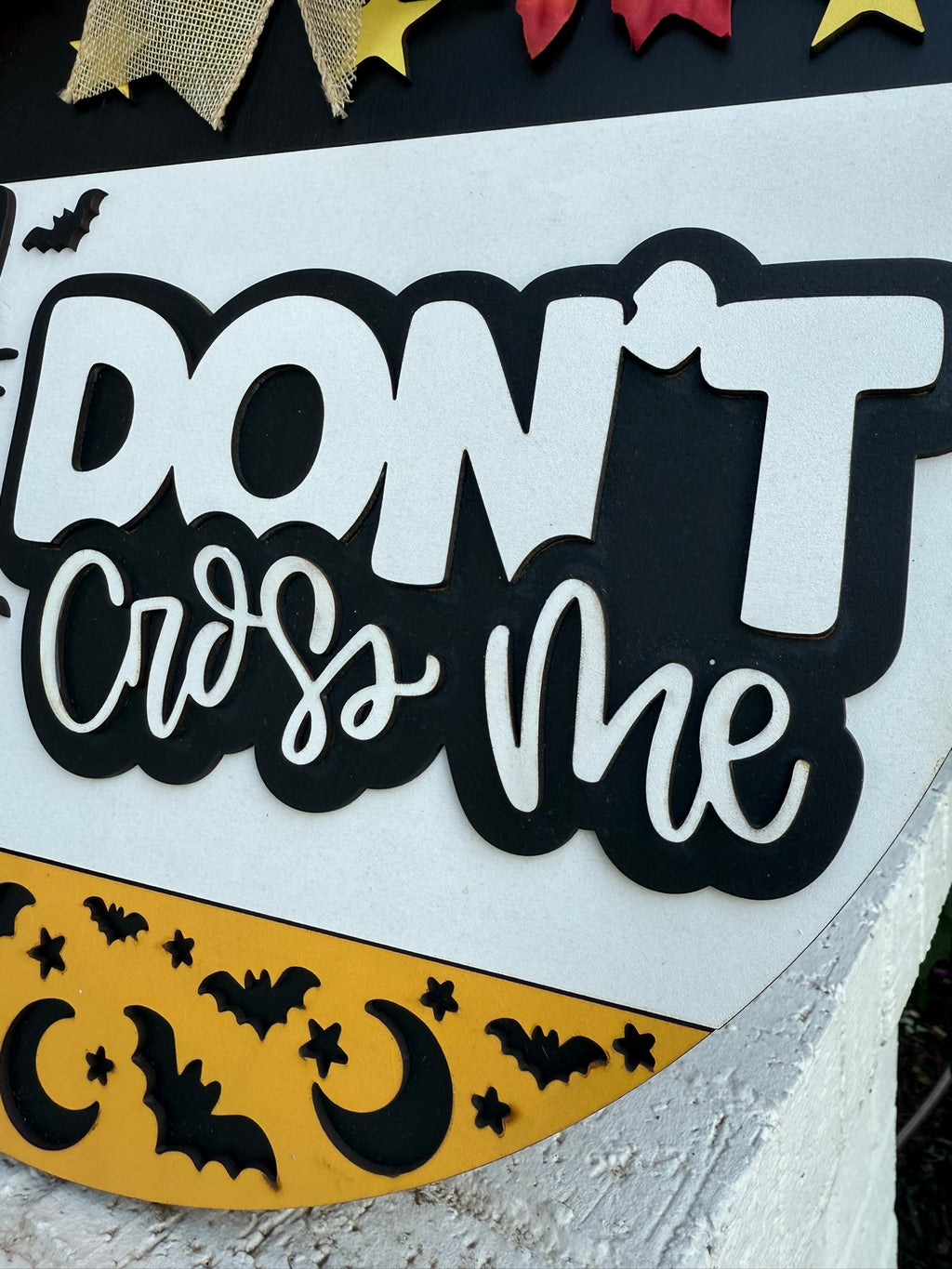 A decorative sign reads DONT cross me in bold black and white letters, with images of bats, yellow stars, and crescent moons along the bottom edge.