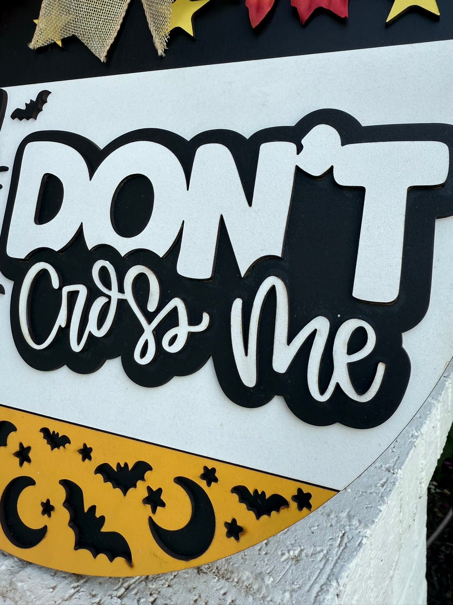 A decorative sign reads DONT cross me in bold black and white letters, with images of bats, yellow stars, and crescent moons along the bottom edge.