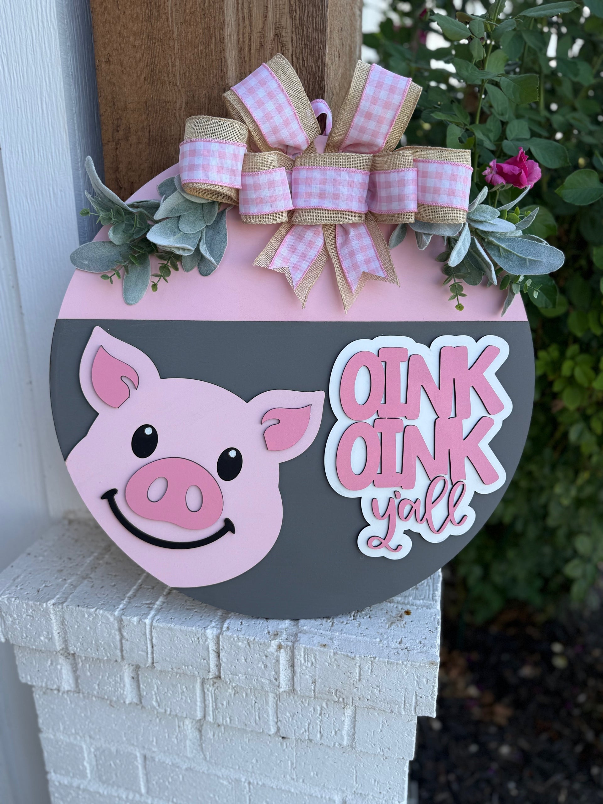 A sign with a pig face and a bow.