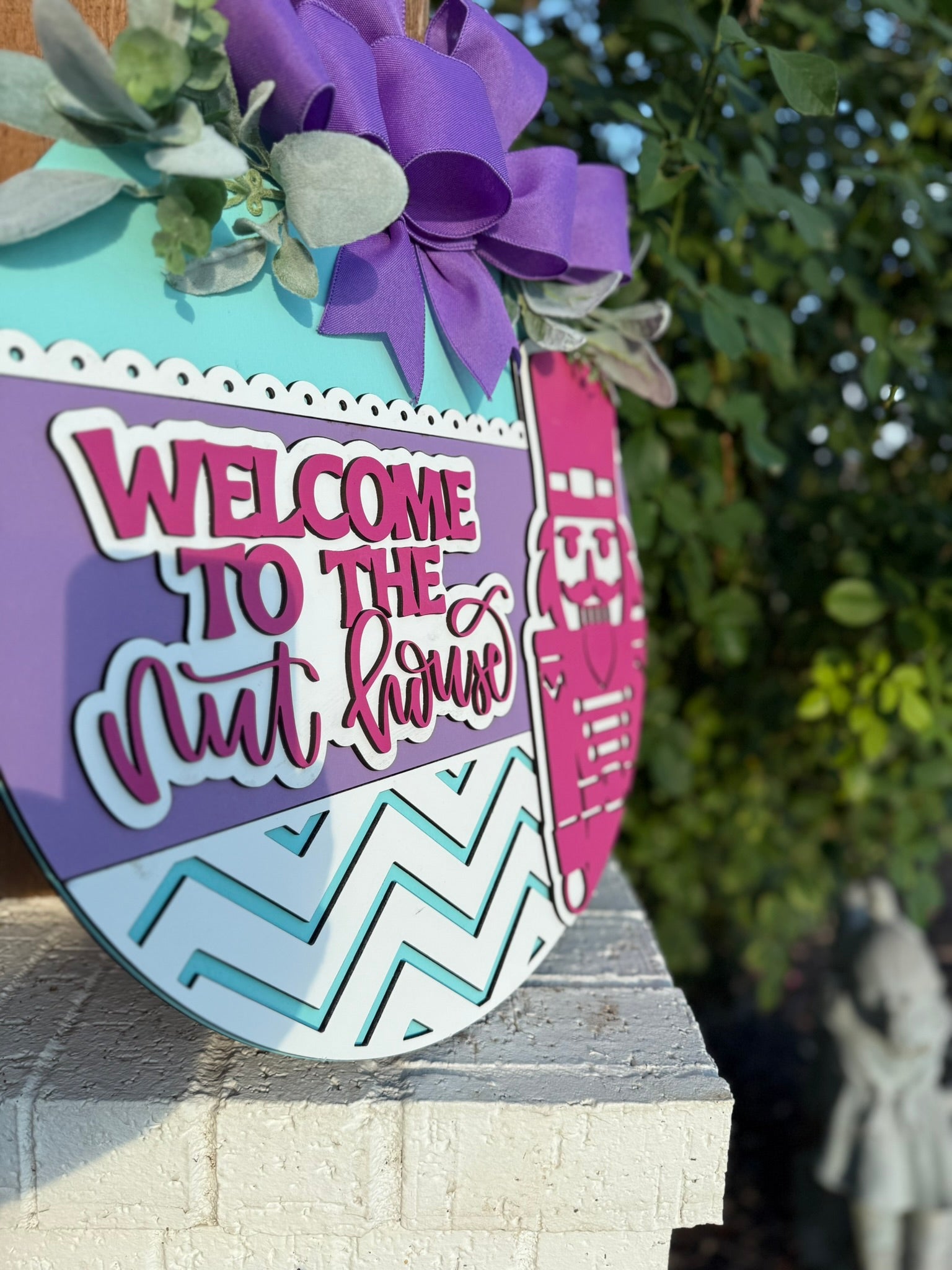 Welcome to the Nut House Door Sign – Nutcracker Christmas Wreath, 3D Layered Wooden Holiday Door Hanger with Purple Bow (16–20”)