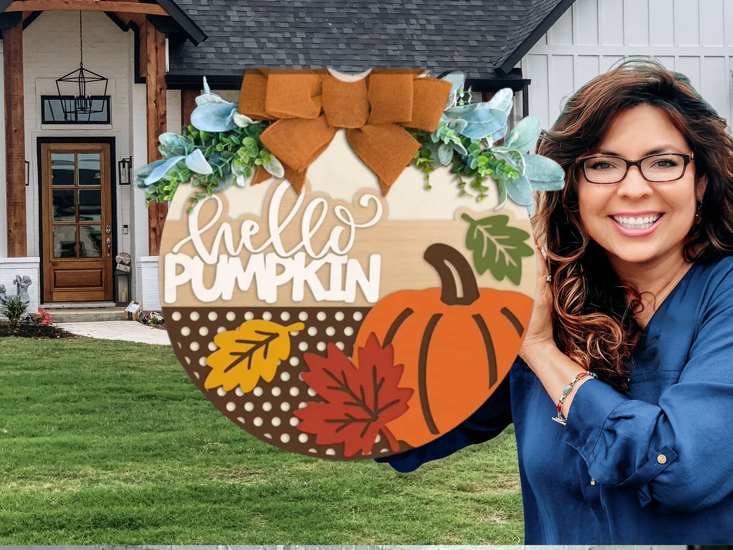 A round wooden sign decorated with a pumpkin, autumn leaves, greenery, a large orange bow, and the words hello PUMPKIN in white letters, displayed on a white brick ledge.