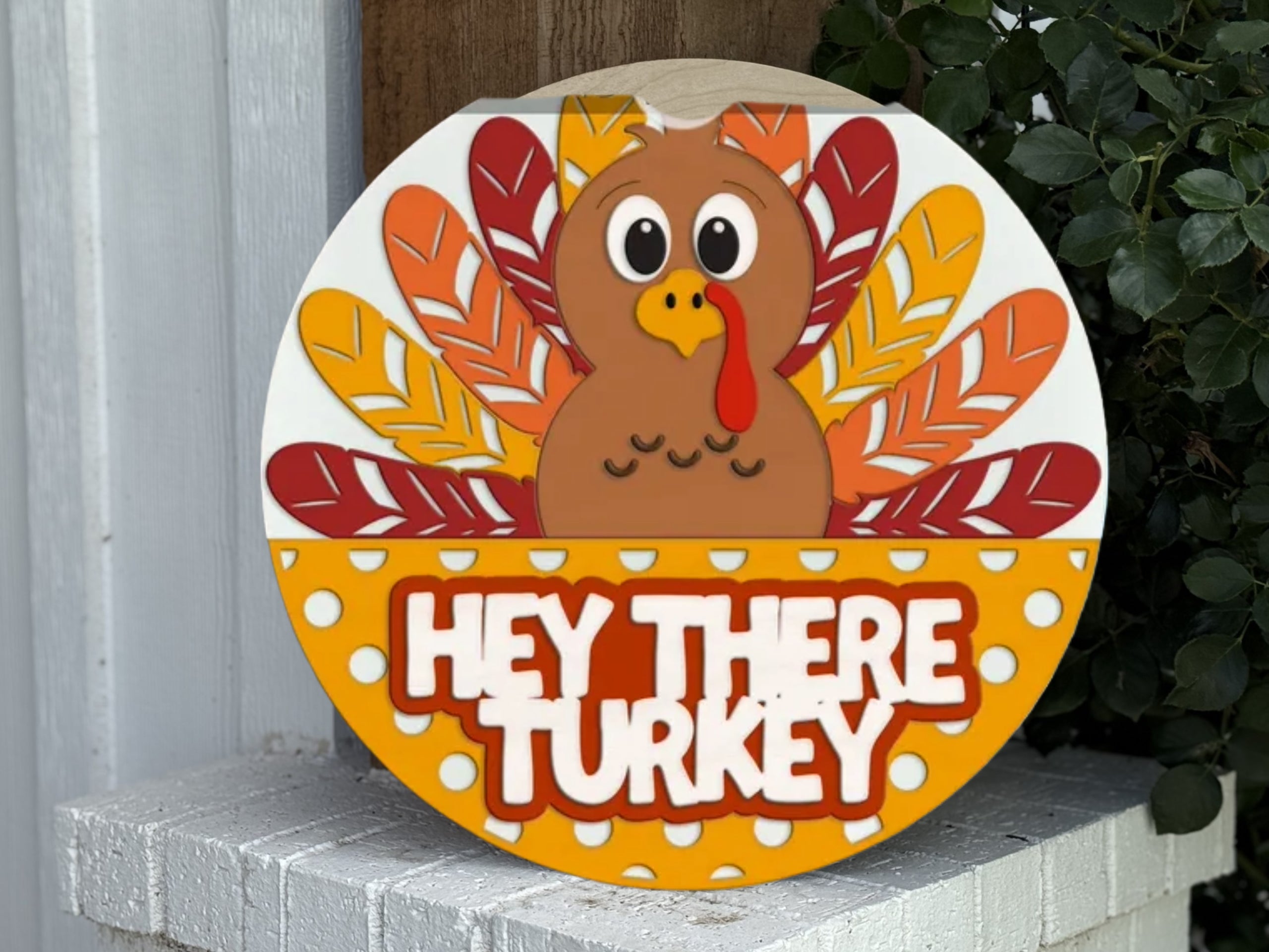 A round sign with a cartoon turkey surrounded by colorful feathers. Below the turkey, the sign reads HEY THERE TURKEY in bold letters on a yellow and white polka dot background.