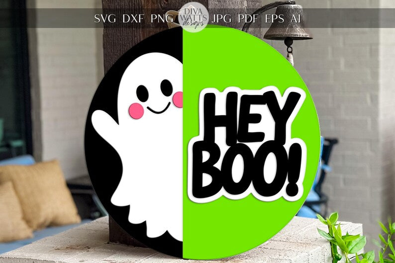 A round sign with a cute, smiling ghost on the left and the words HEY BOO! in bold black letters on a bright green background on the right. The sign is displayed outdoors near pillows and plants.