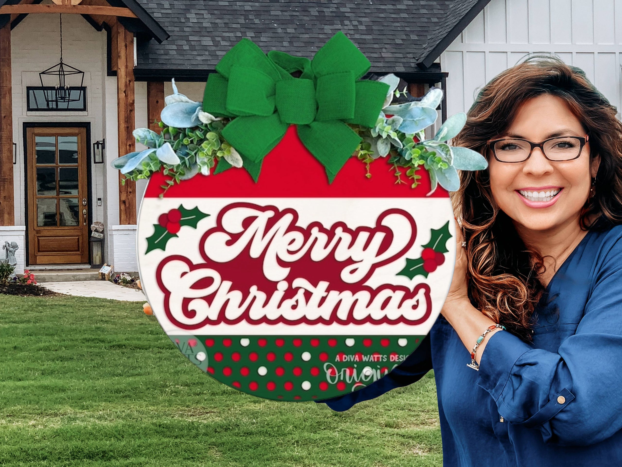 A smiling woman with long, wavy hair and glasses stands in front of a modern house, holding a large red and white Merry Christmas sign decorated with holly and a green bow.