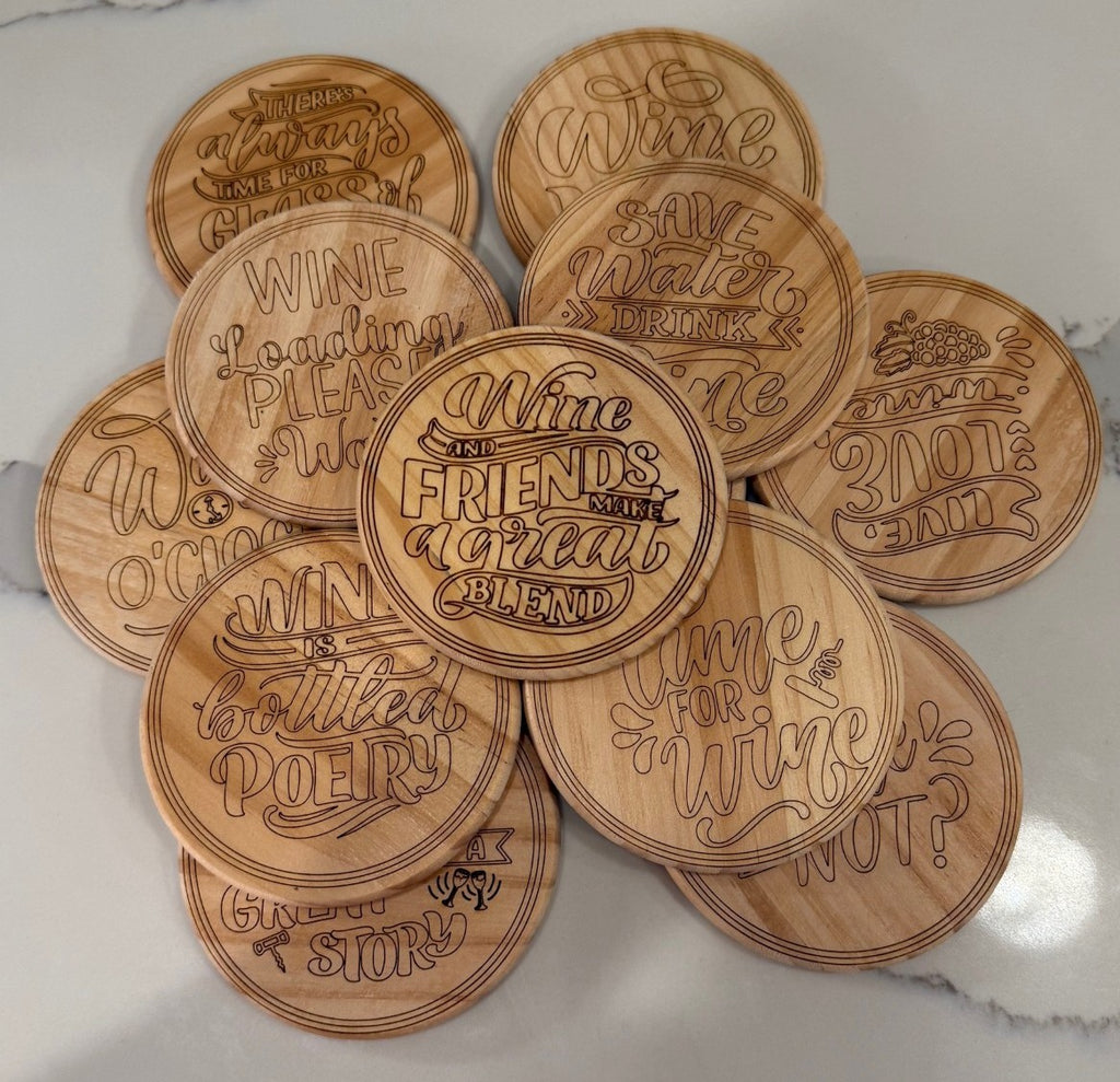 The set of 4 round wooden coasters, titled Funny Wine Sayings, features playful wine sayings in various fonts with unique elements like wine bottles and glasses, all arranged on a white marble surface.