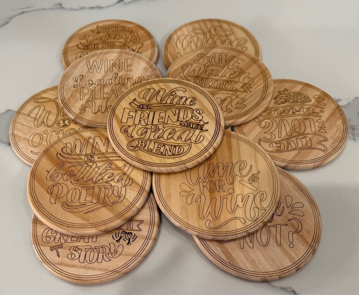 The set of 4 round wooden coasters is engraved with whimsical wine sayings like Wine and Friends Make a Great Blend and Wine OClock, etched in playful fonts. This collection adds rustic charm when stacked on a marble surface.