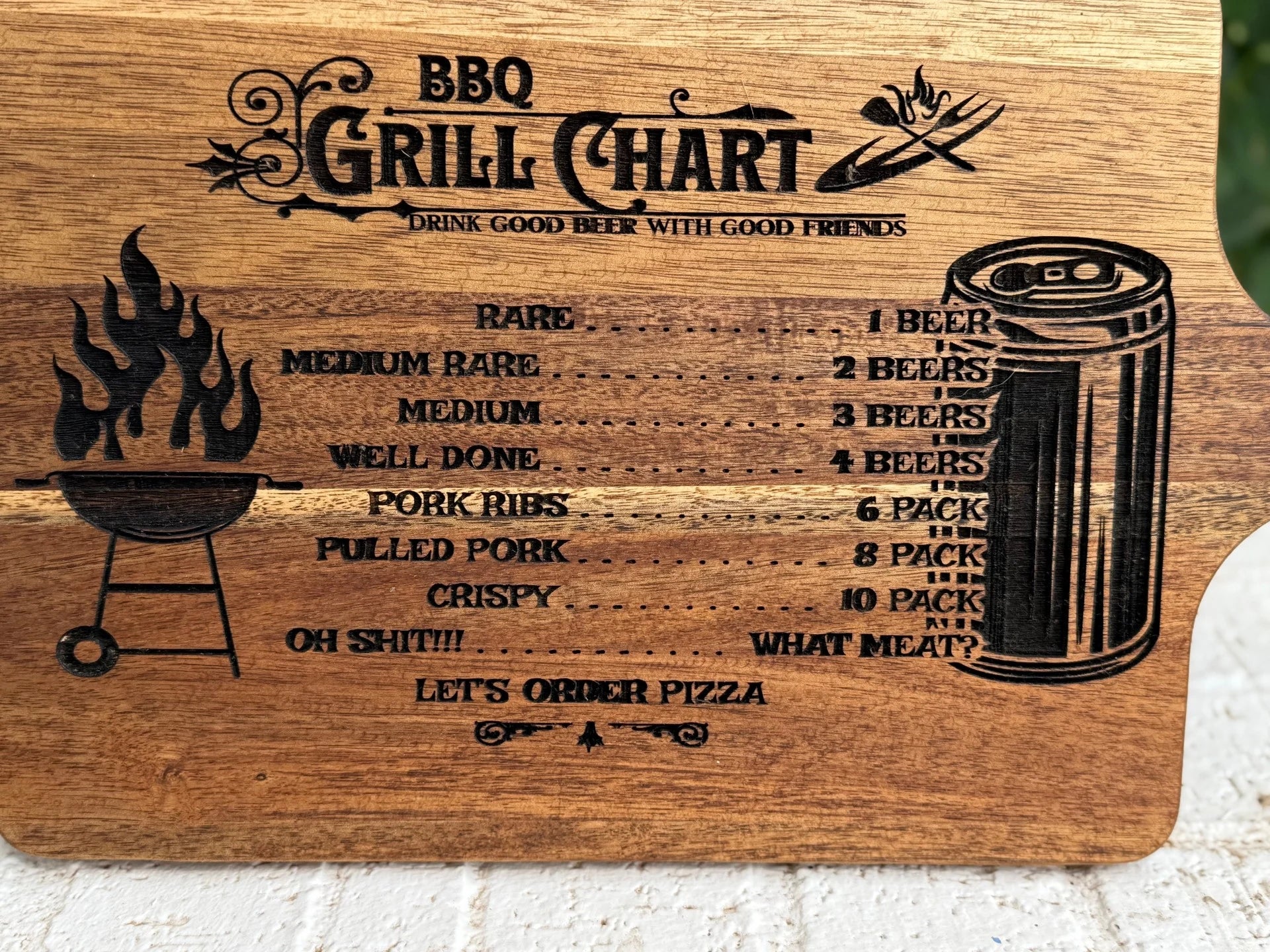 The BBQ Grill Chart engraved Acacia Wood Cutting Board lists meat doneness with matching beer—from Rare (1 beer) to Crispy (10 pack)—plus fun engravings like “Oh Shit!!!” and “What meat? LETS ORDER PIZZA. Grill and beer can icons are included.