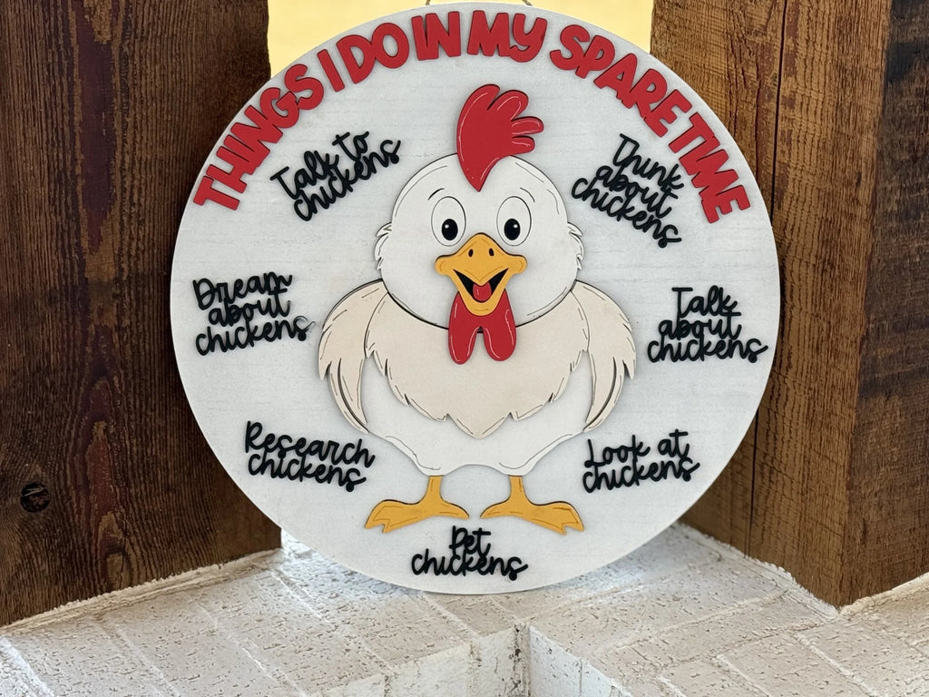 A round sign featuring a cartoon chicken in the center with a red comb and happy expression. Surrounding the chicken are phrases like Research chickens, Talk about chickens, Pet chickens, and others, all related to spending time with chickens. The top reads, Things I do in my spare time.