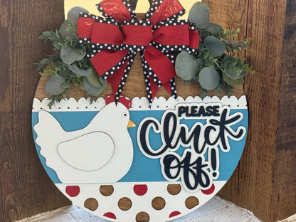 Round wooden sign with a decorative chicken, red and white polka dots, and blue background. It features a red and black polka-dotted bow, green foliage, and the phrase Please Cluck Off! in bold black letters. The sign is set against a rustic wood backdrop.